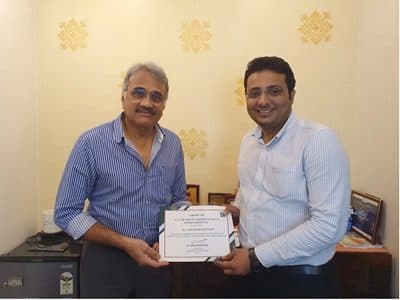 Dr. Yash Shah receiving a certificate from a senior colleague