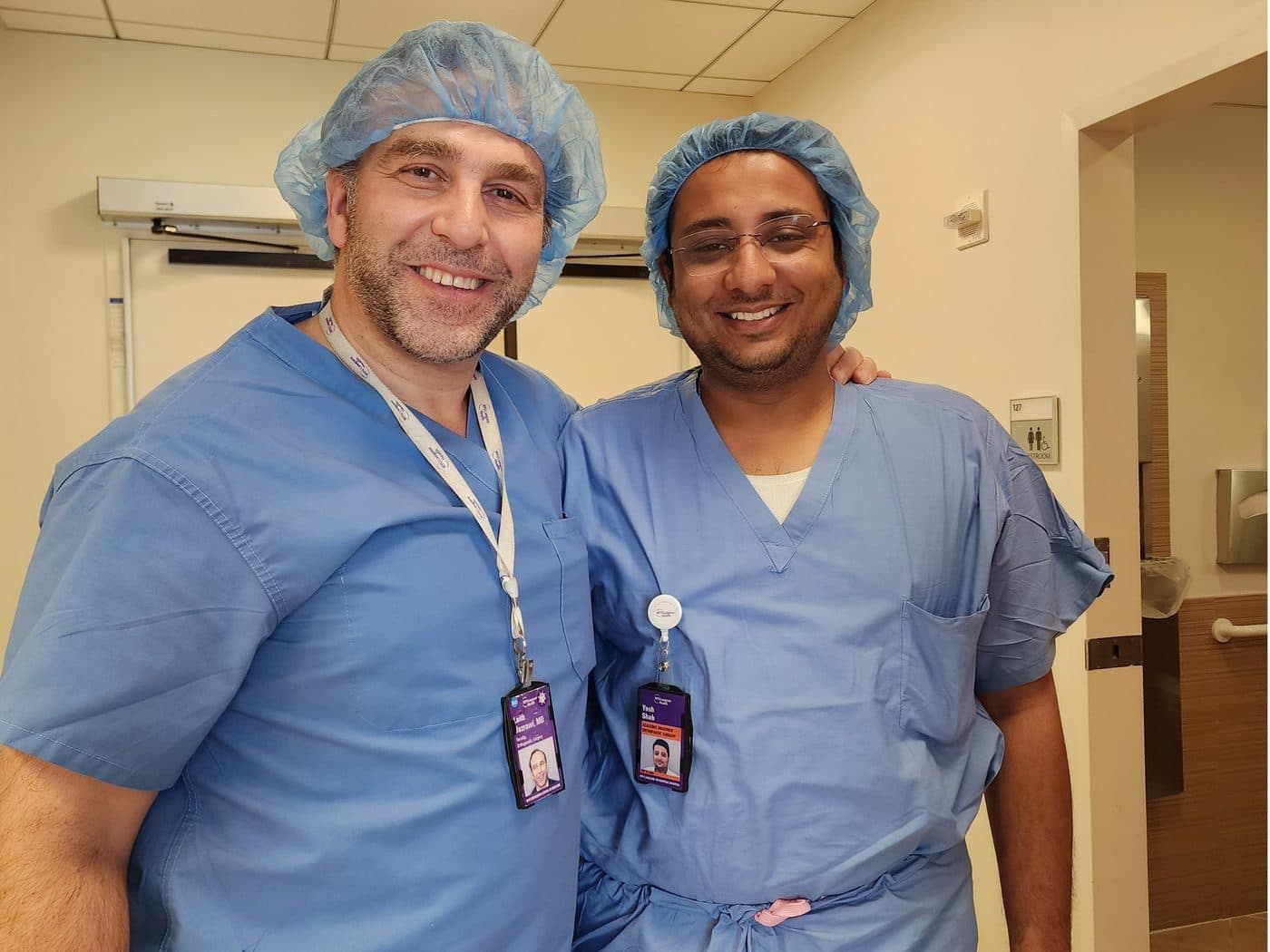 Dr. Yash Shah in scrubs with a senior surgeon