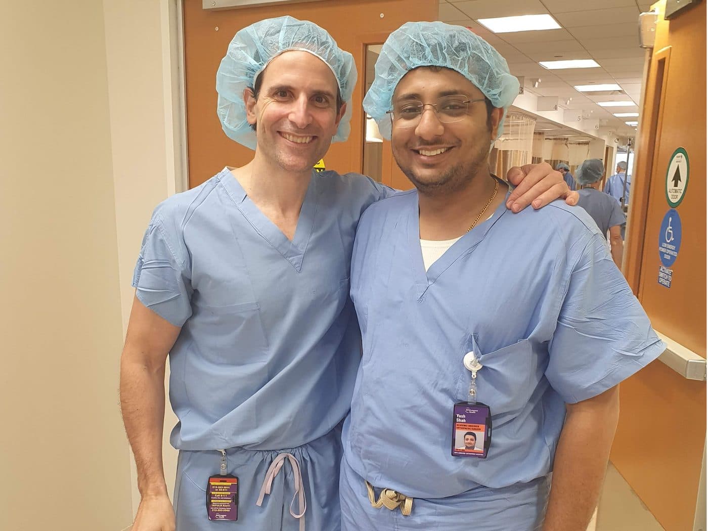 Dr. Yash Shah with a surgical mentor in an operating theatre corridor